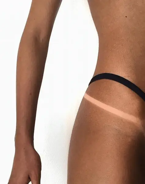 Tanned skin with visible bikini line tan.
