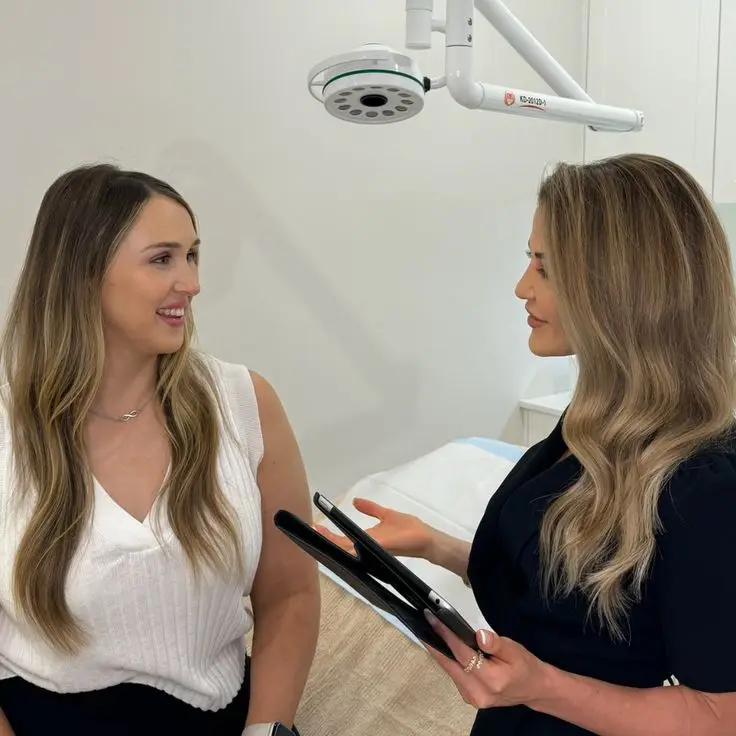 Two women discussing in a medical consultation room.