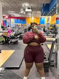 Person taking gym mirror selfie in workout clothes.