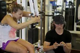 Woman exercising with coach in gym.